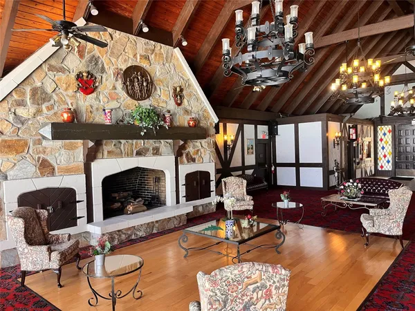 a living room with furniture a fireplace and a chandelier
