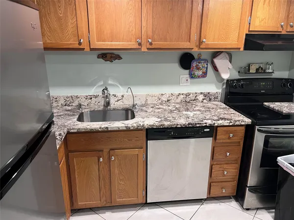 a kitchen with granite countertop a sink and cabinets