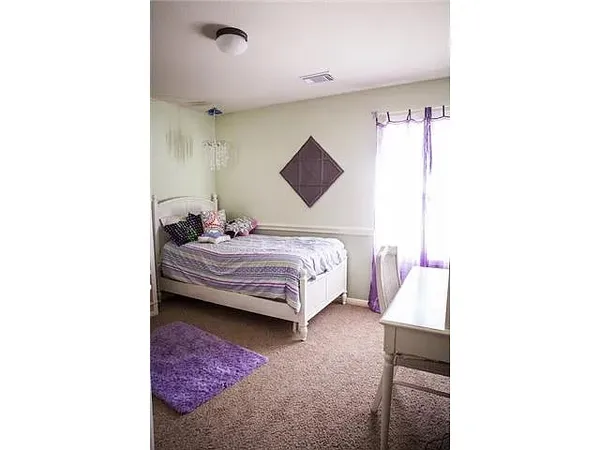 a bedroom with a bed and a wall painting