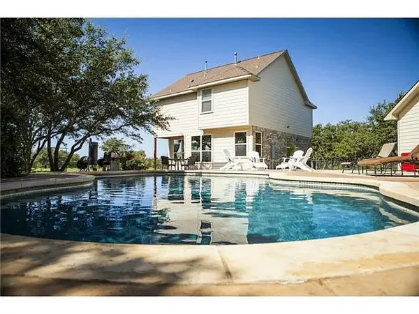 a view of a house with pool and sitting area