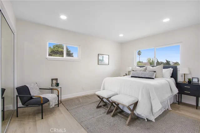 a spacious bedroom with a bed and a chair