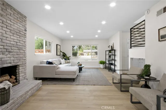 a living room with fireplace furniture and a wooden floor
