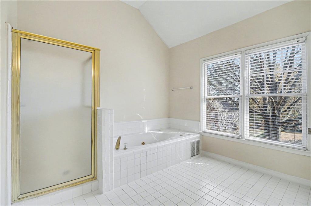 7170 Threadstone Overlook Duluth, GA 30097 - Photo 21 of 26 a bathroom with a bathtub a shower a sink and a window