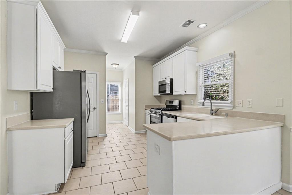 7170 Threadstone Overlook Duluth, GA 30097 - Photo 10 of 26 a kitchen with stainless steel appliances a refrigerator sink and stove