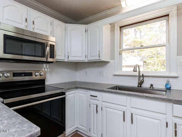 a kitchen with white cabinets and white appliances