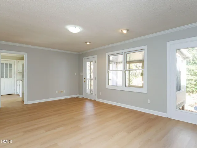 a kitchen with granite countertop white cabinets appliances a sink and a window