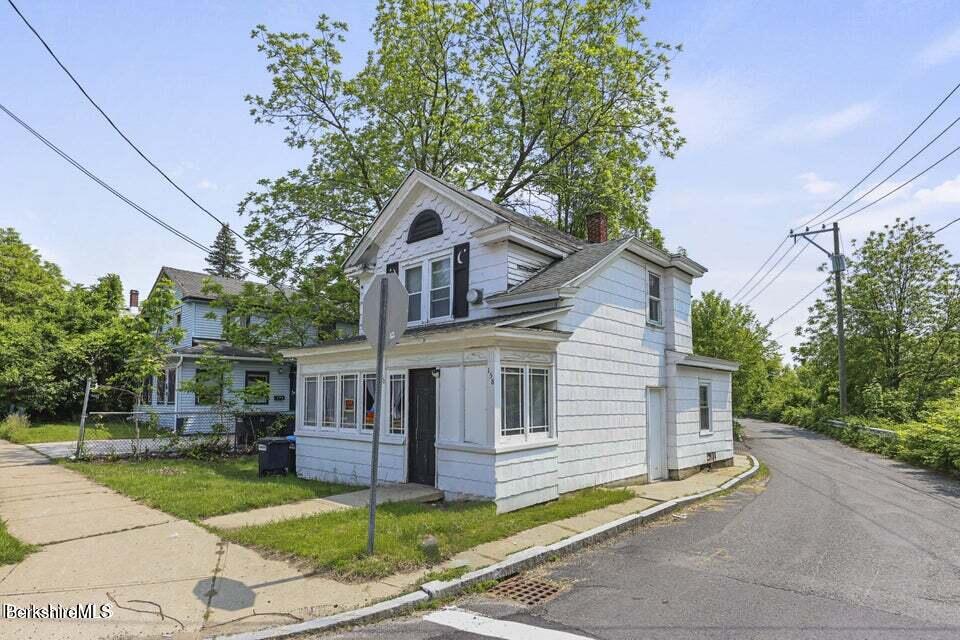 21 Pleasant Street Pittsfield, MA 01201 - Photo 15 of 16 a front view of a house with a garden and trees