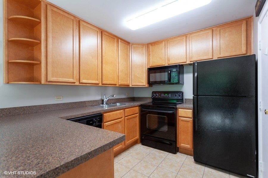 6008 Forest View Road, Unit 1D Lisle, IL 60532 - Photo 6 of 22 a kitchen with granite countertop stainless steel appliances and wooden cabinets
