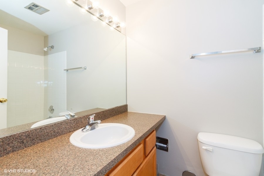 6008 Forest View Road, Unit 1D Lisle, IL 60532 - Photo 10 of 22 a bathroom with a granite countertop sink and a mirror