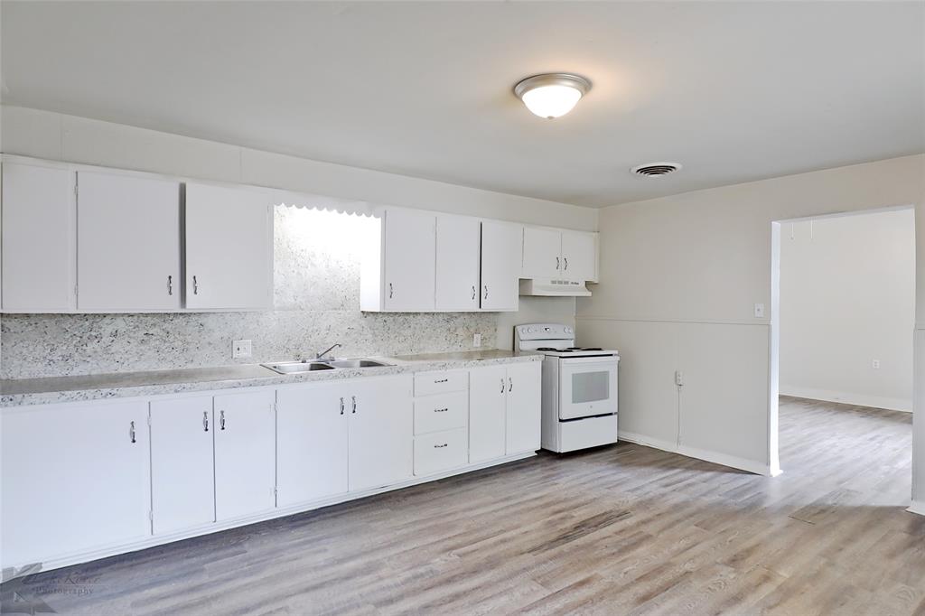 858 Beech Street Abilene, TX 79601 - Photo 12 of 24 a kitchen with granite countertop white cabinets and white stainless steel appliances