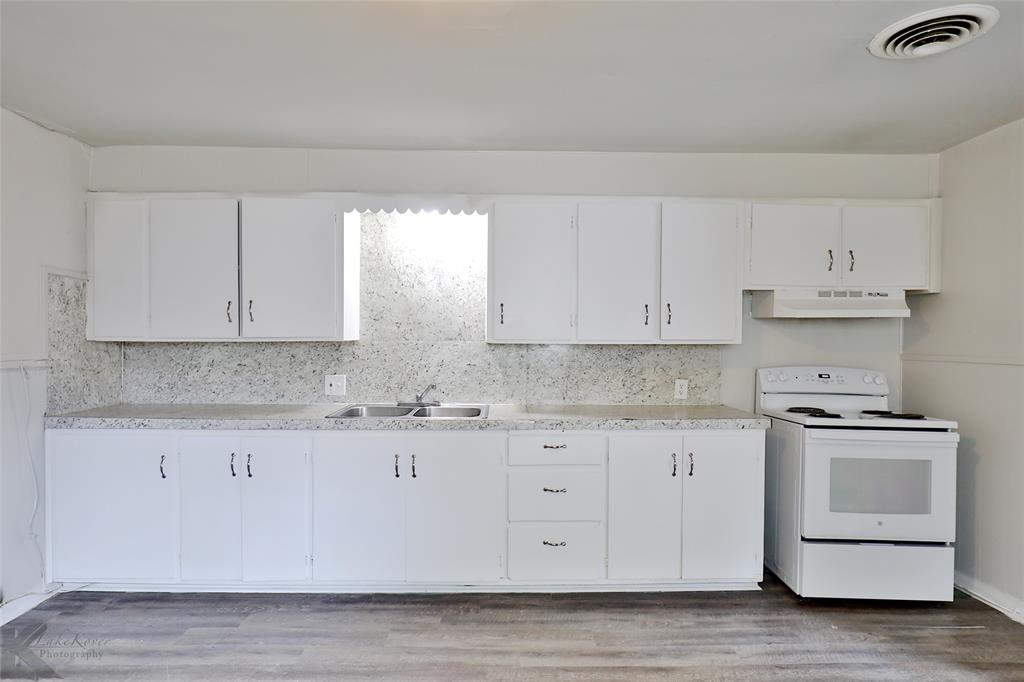 858 Beech Street Abilene, TX 79601 - Photo 13 of 24 a kitchen with granite countertop white cabinets and a stove