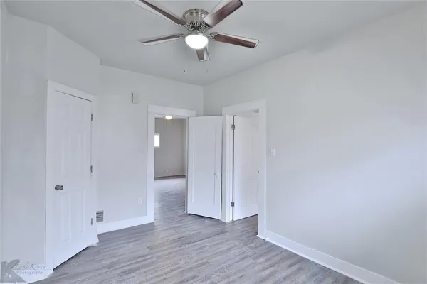a view of an empty room with wooden floor