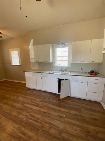 a kitchen with granite countertop a sink and cabinets