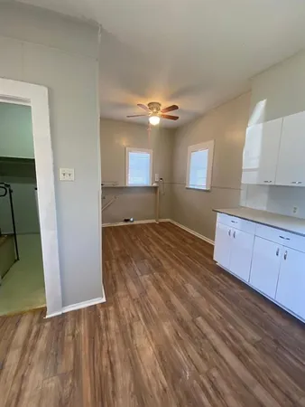 an empty room with wooden floor and cabinet