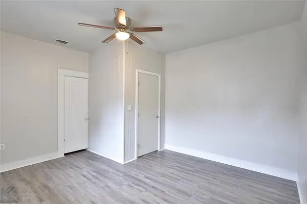 a view of an empty room with wooden floor