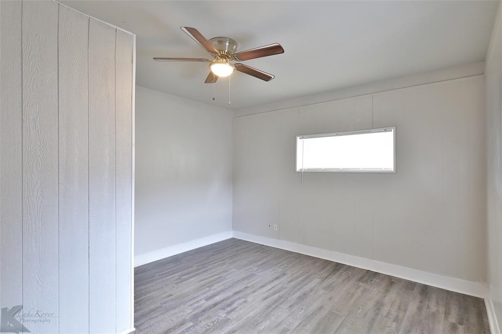 858 Beech Street Abilene, TX 79601 - Photo 7 of 24 a view of an empty room with wooden floor and a window