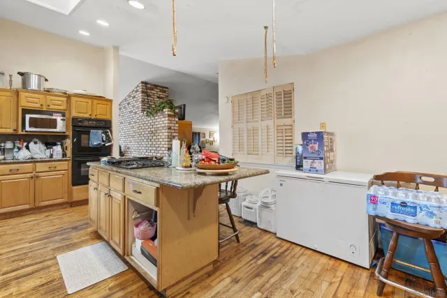 a kitchen with stainless steel appliances granite countertop a stove and a wooden floors