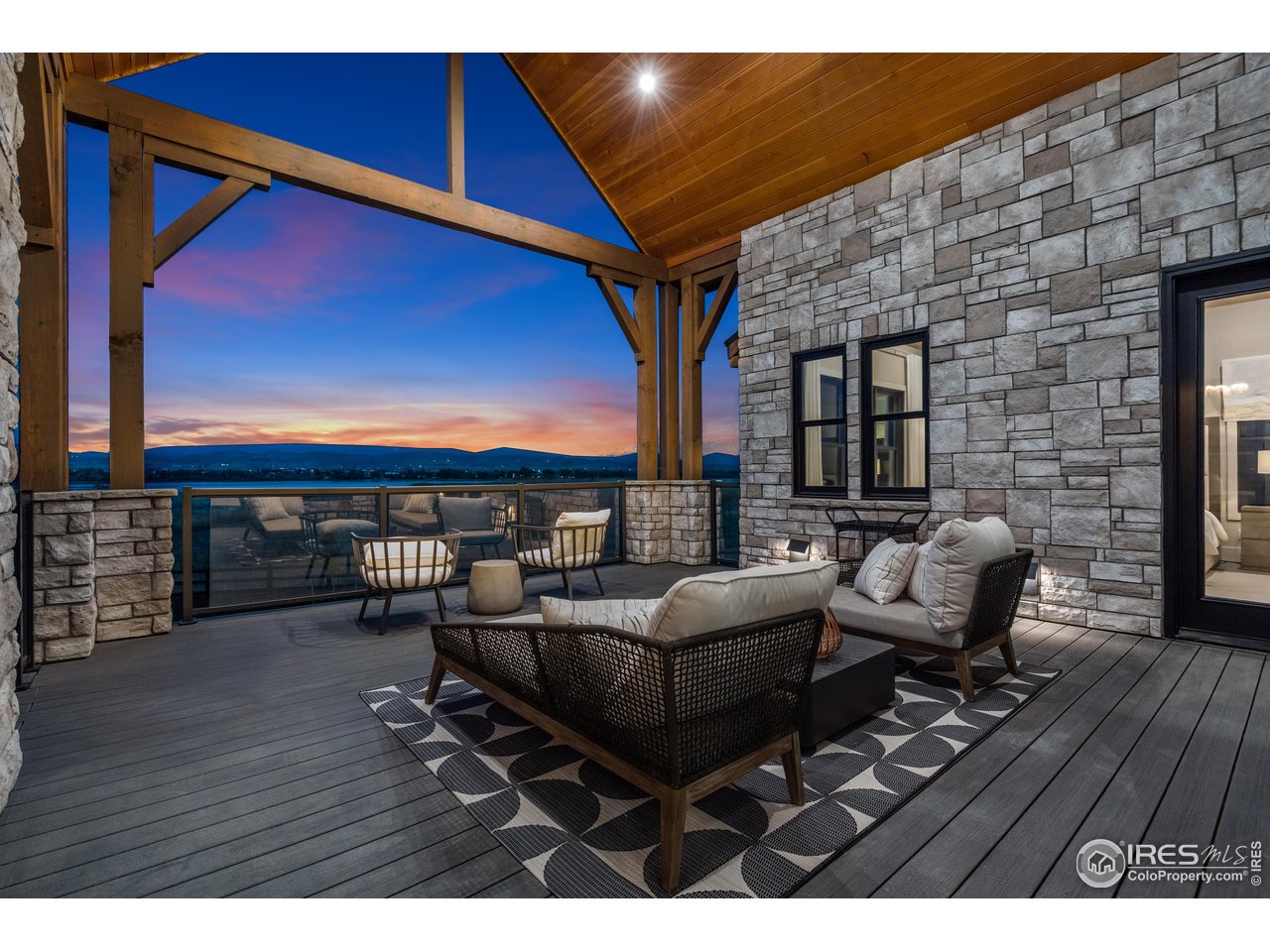 2517 Southwind Road Berthoud, CO 80513 - Photo 38 of 50 Evenings on the covered deck invite quiet reflection and connection, as breathtaking sunsets unfold across the mountain horizon in a setting designed for comfort and calm.