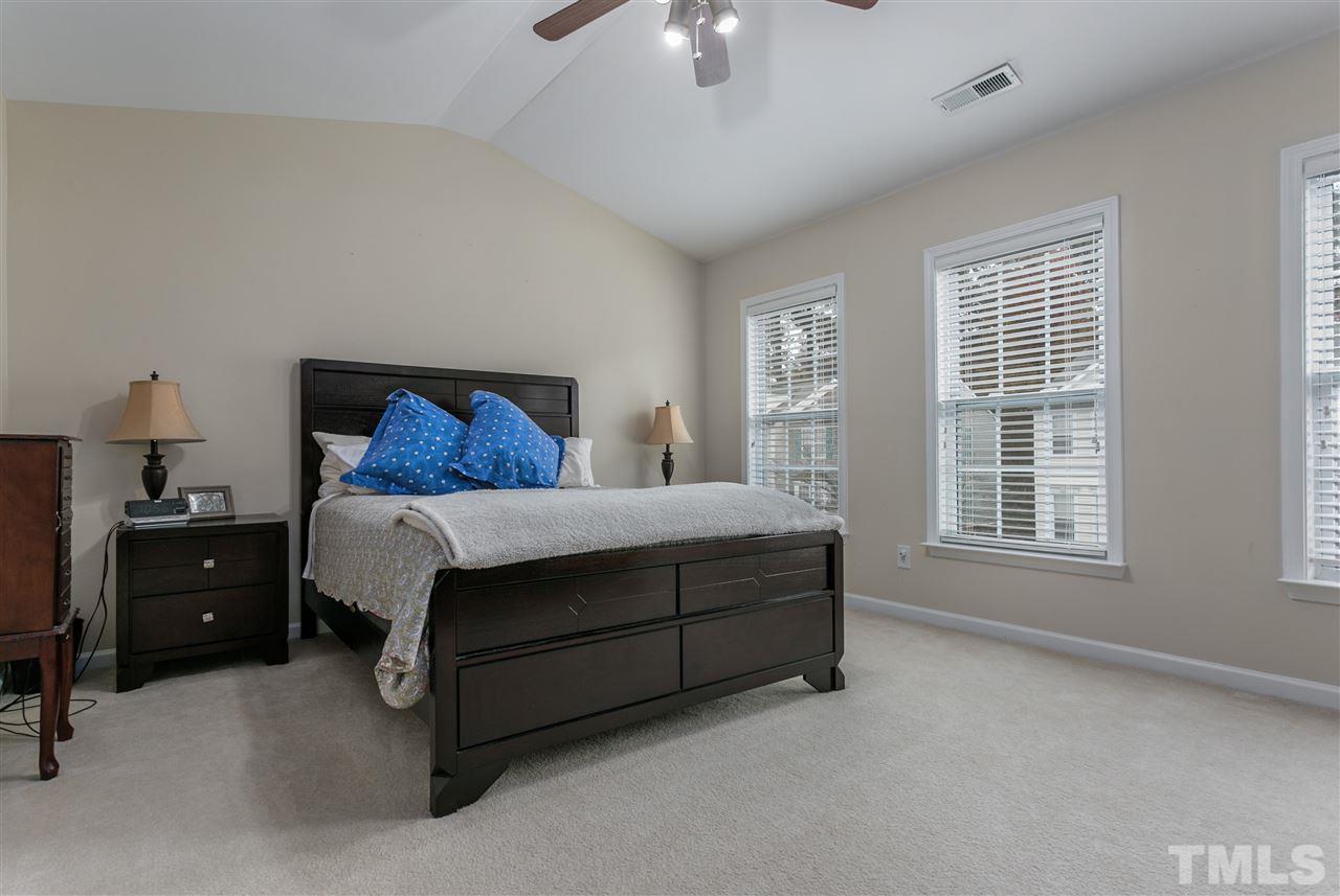5505 Red Robin Road Raleigh, NC 27613 - Photo 10 of 19 a bedroom with a bed and a chandelier