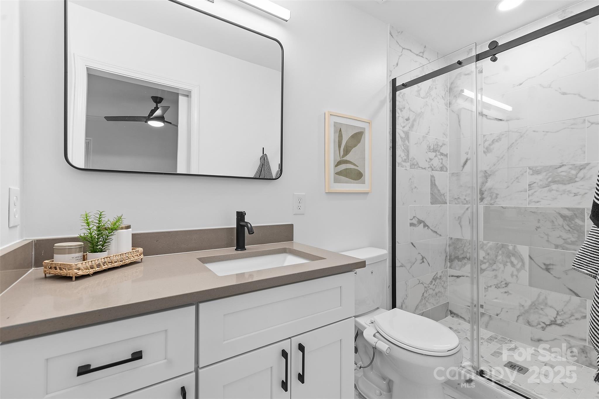917 Scaleybark Road Charlotte, NC 28209 - Photo 22 of 42 a bathroom with a granite countertop sink mirror vanity and toilet