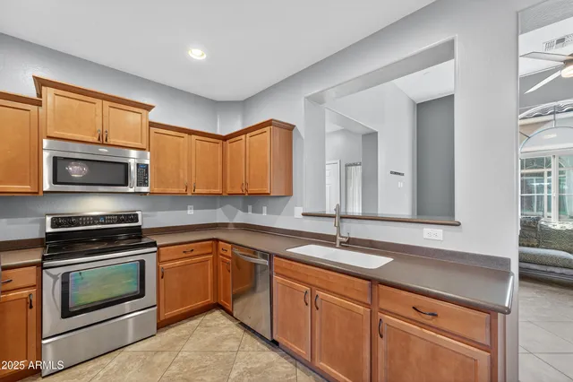 a kitchen with stainless steel appliances granite countertop a refrigerator and a stove top oven