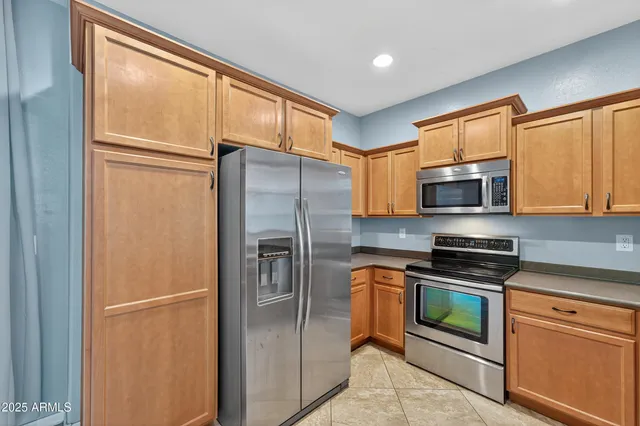 a kitchen with stainless steel appliances granite countertop a refrigerator and cabinets