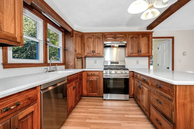 a kitchen with stainless steel appliances granite countertop a sink a stove and a refrigerator