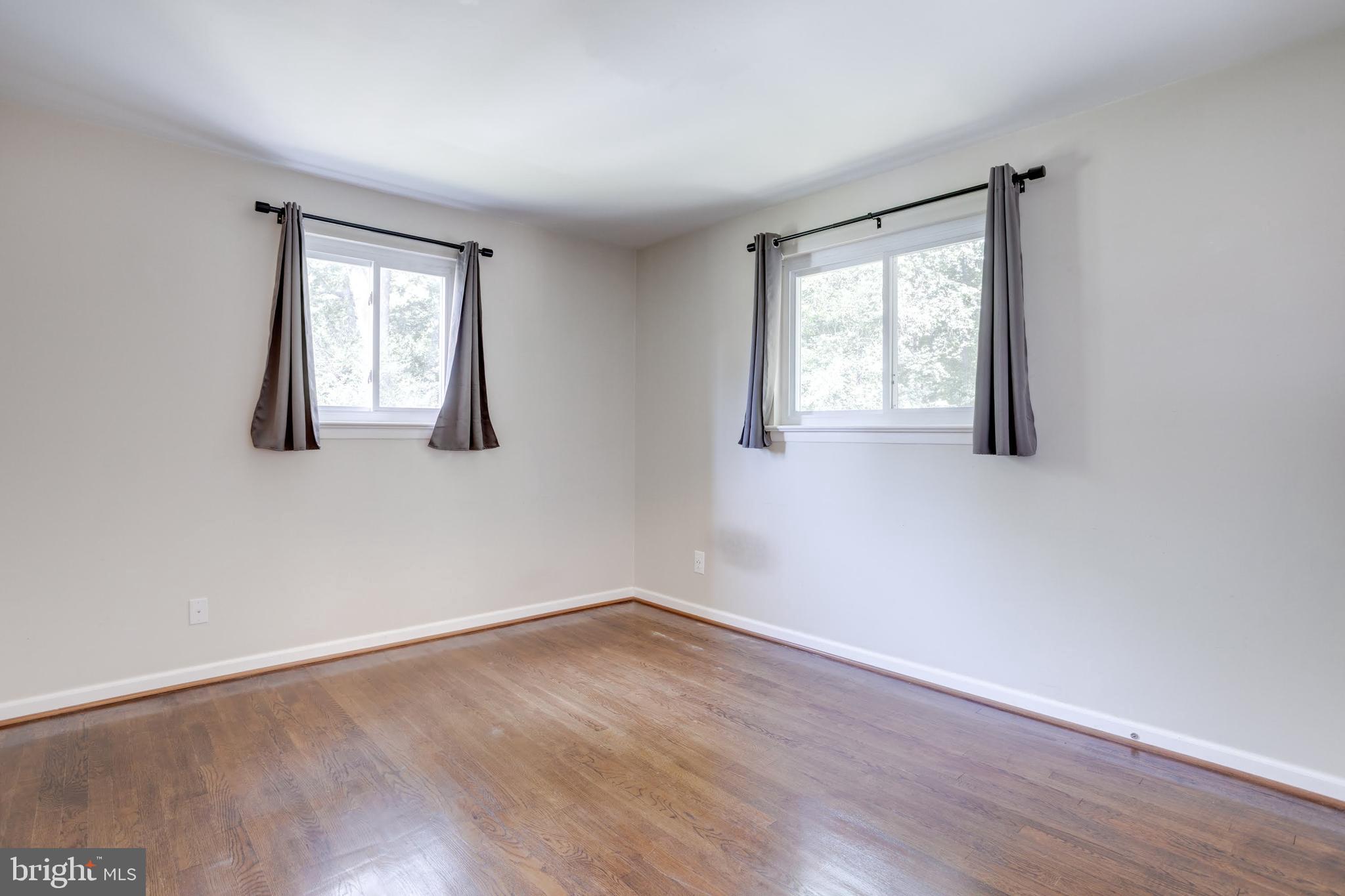 7424 Nancemond Street Springfield, VA 22150 - Photo 13 of 59 an empty room with wooden floor and windows