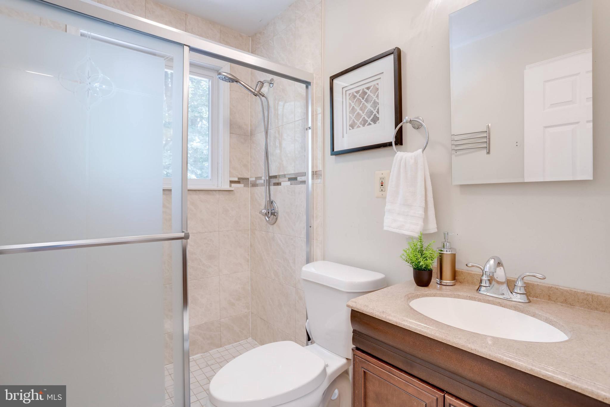 7424 Nancemond Street Springfield, VA 22150 - Photo 14 of 59 a bathroom with a granite countertop sink toilet and shower