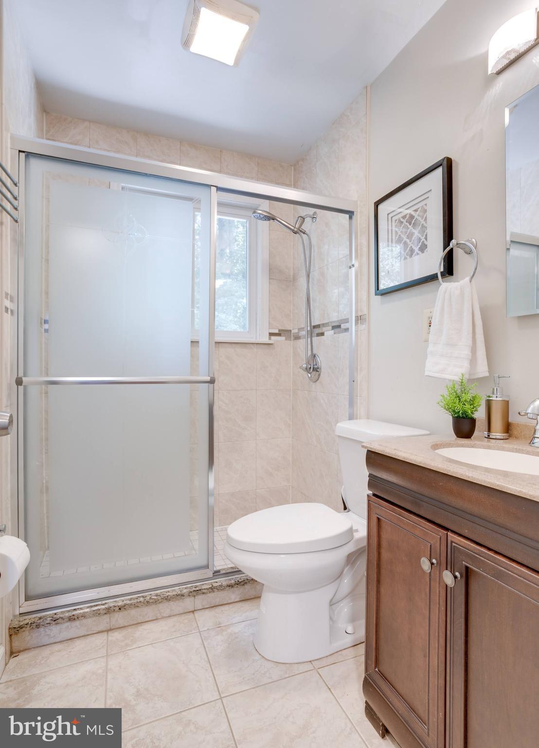 7424 Nancemond Street Springfield, VA 22150 - Photo 15 of 59 a bathroom with a granite countertop sink a toilet and a shower