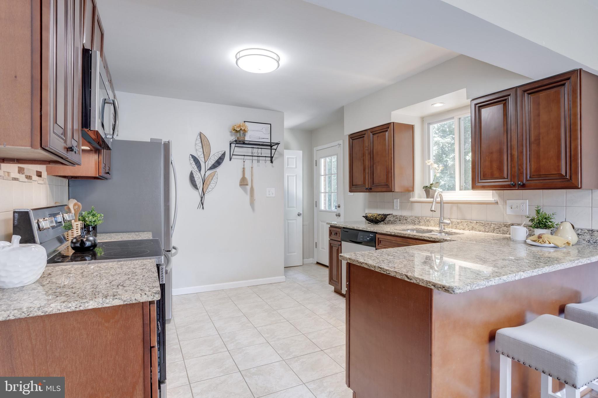 7424 Nancemond Street Springfield, VA 22150 - Photo 24 of 59 a kitchen with stainless steel appliances granite countertop a sink stove and refrigerator