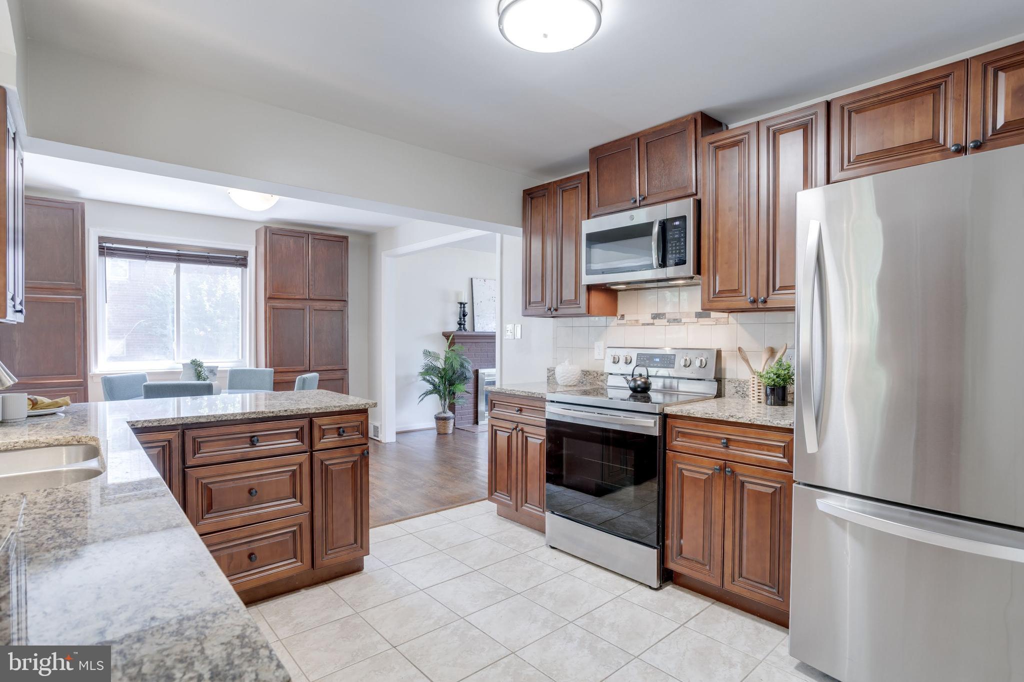 7424 Nancemond Street Springfield, VA 22150 - Photo 26 of 59 a kitchen with stainless steel appliances granite countertop a refrigerator stove and sink