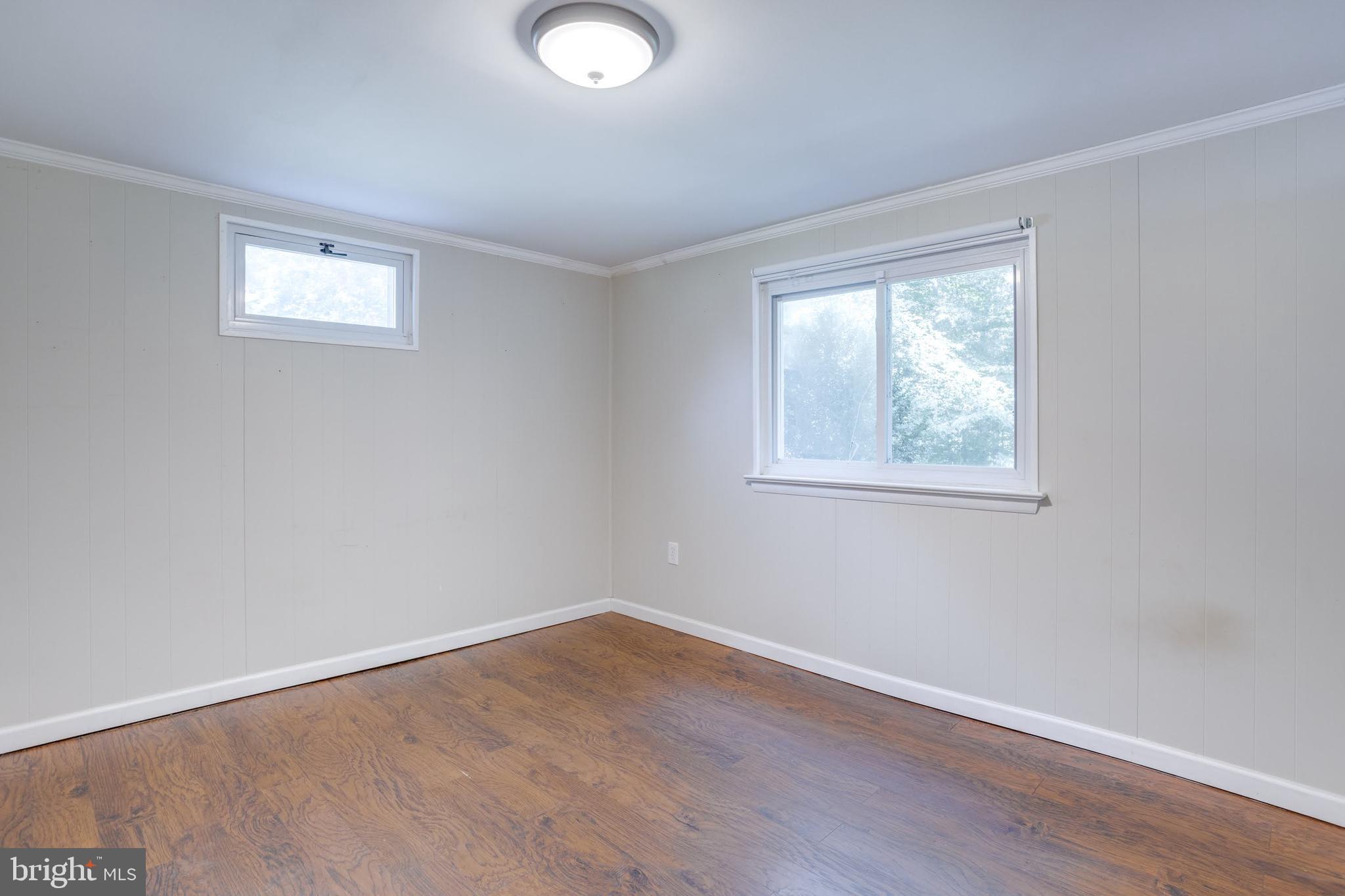 7424 Nancemond Street Springfield, VA 22150 - Photo 27 of 59 a view of an empty room with wooden floor and a window