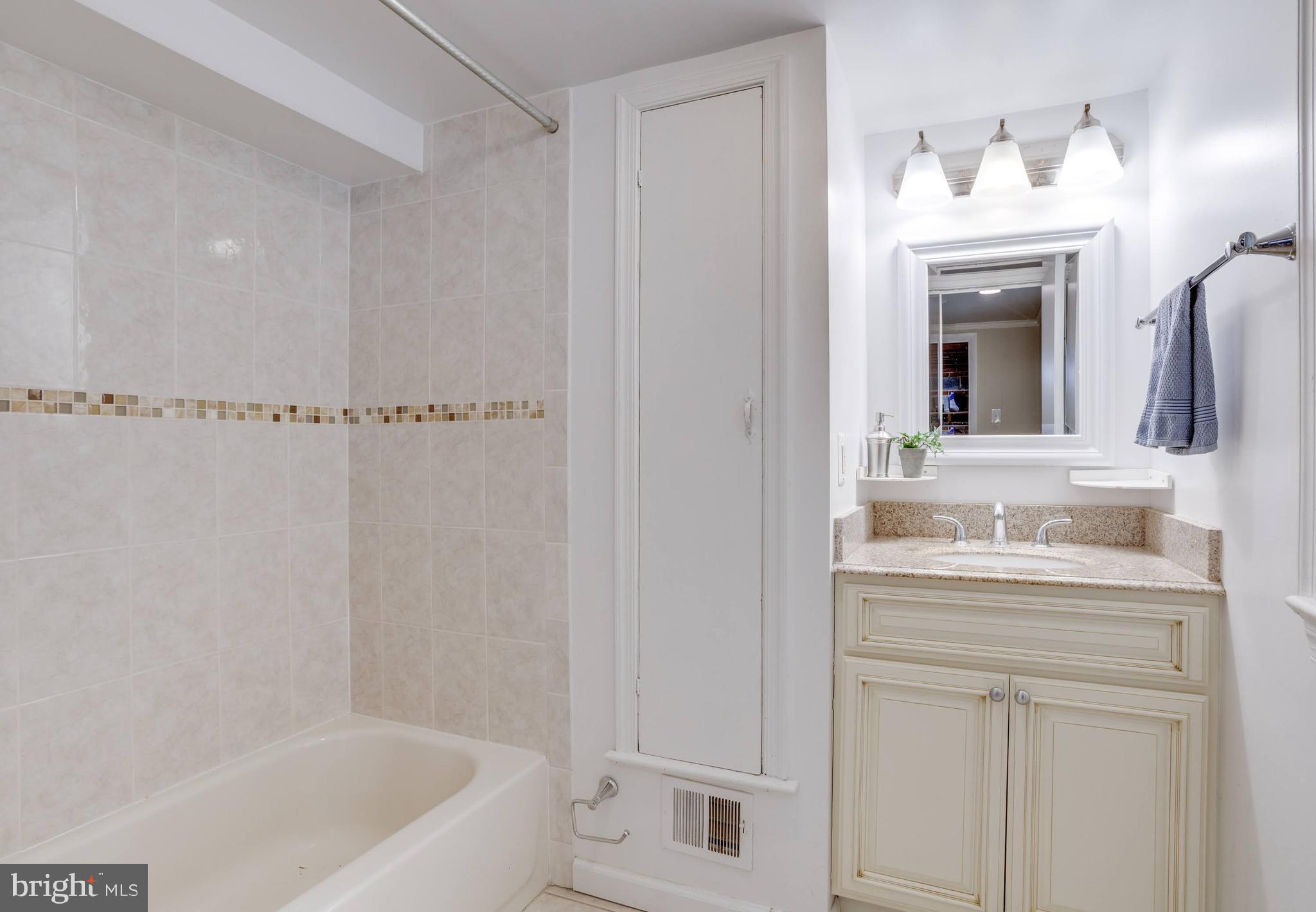 7424 Nancemond Street Springfield, VA 22150 - Photo 34 of 59 a bathroom with a bathtub a sink a vanity and a window