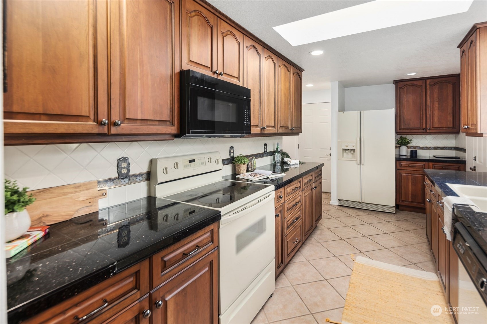 14844 Southeast 116th Street Renton, WA 98059 - Photo 9 of 38 a kitchen with stainless steel appliances granite countertop a sink a stove a microwave and a refrigerator