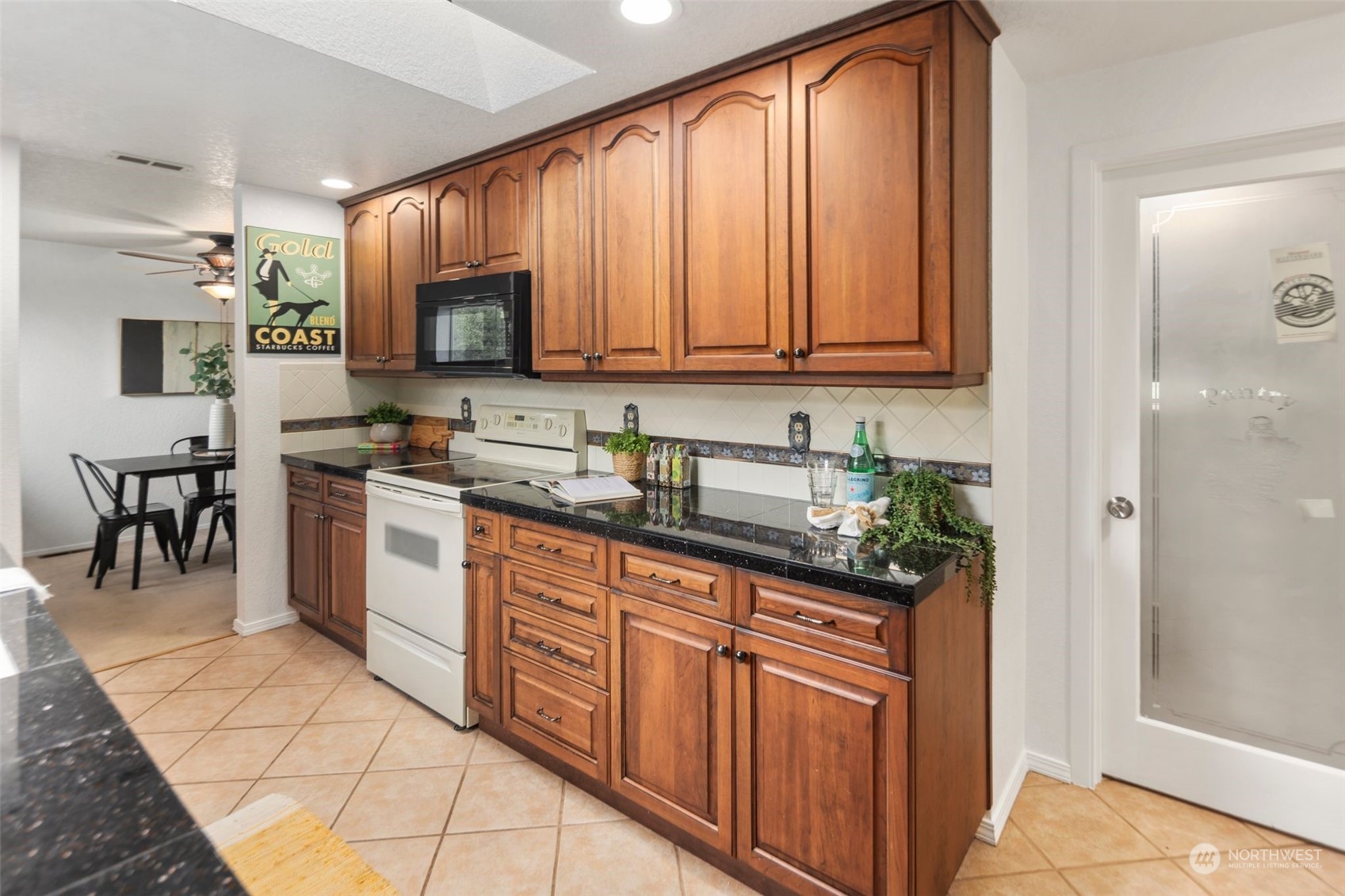 14844 Southeast 116th Street Renton, WA 98059 - Photo 10 of 38 a kitchen with stainless steel appliances granite countertop a stove a sink and a refrigerator