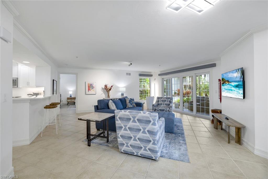 376 3rd Street South, Unit 102 Naples, FL 34102 - Photo 5 of 17 Living area with crown molding and light tile patterned floors