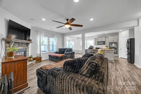 a living room with furniture a flat screen tv and kitchen view