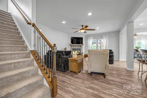 a view of a living room and kitchen with furniture wooden floor and windows