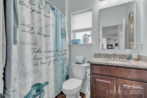 a bathroom with a granite countertop toilet sink and shower