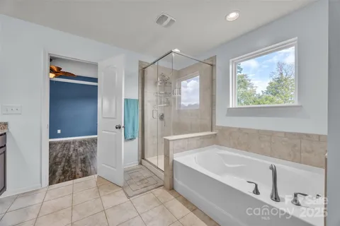 a spacious bathroom with a tub shower and sink
