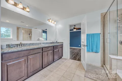 a bathroom with a granite countertop double vanity sink and mirror
