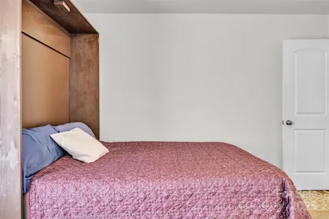 a bedroom with a bed and a lamp with wooden floor