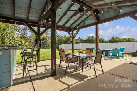 a view of a patio with a table chairs and a floor to ceiling window next to a yard