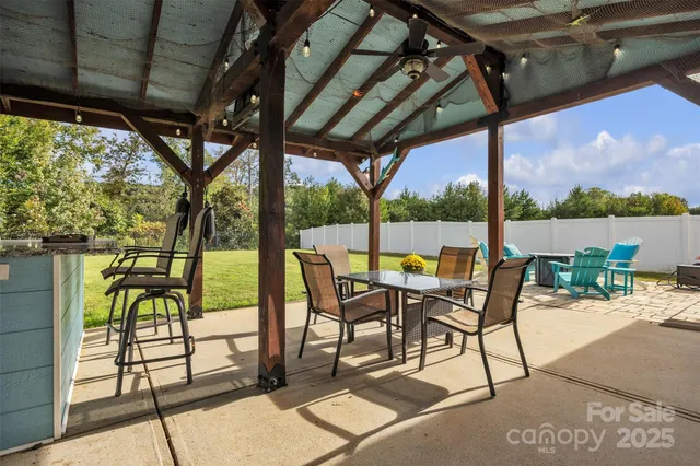 a view of a patio with a table chairs and a floor to ceiling window next to a yard