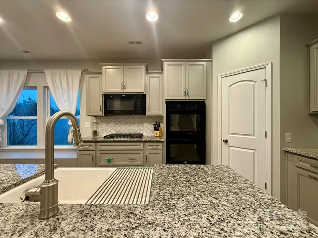 a kitchen with stainless steel appliances granite countertop a refrigerator stove and sink