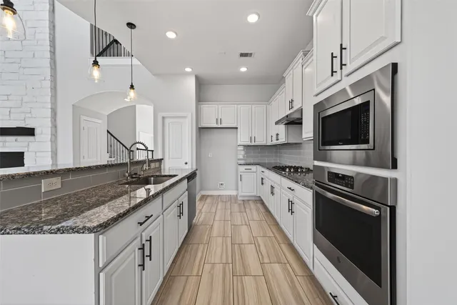 a kitchen with kitchen island a sink and a stove