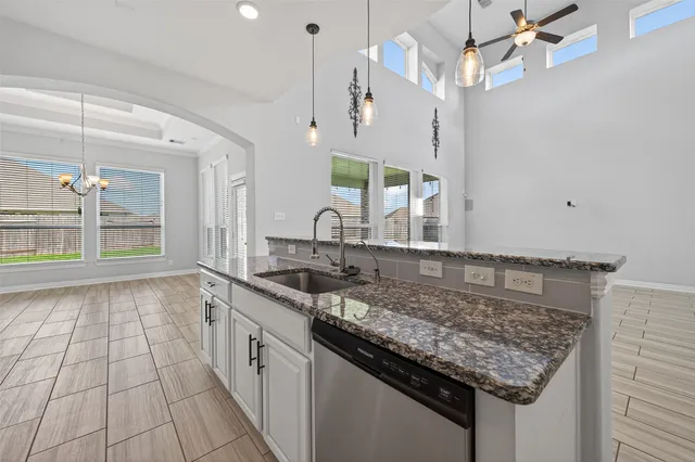 a kitchen with granite countertop white cabinets and sink
