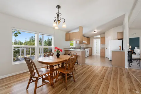 a view of a dining room with furniture a chandelier and wooden floor