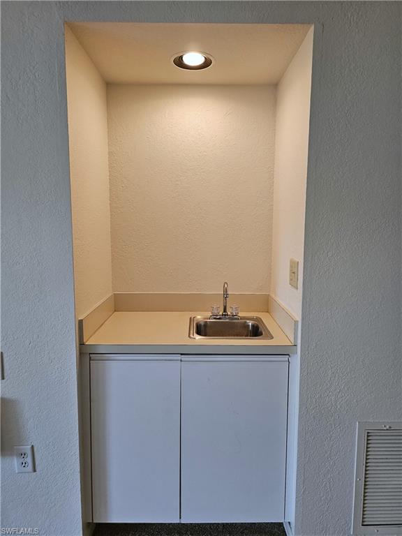 6025 Chardonnay Lane, Unit 102 Naples, FL 34119 - Photo 15 of 37 a bathroom with a sink and mirror